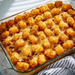Bacon cheeseburger casserole with tater tots, topped with cheese and bacon