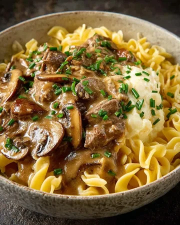 Delicious beef stroganoff served over pasta with a creamy sauce.