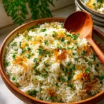 A bowl of Herbed Rice Pilaf garnished with fresh herbs and spices.