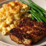 Plate of crispy baked pork chops garnished with herbs