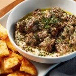 Bowl of traditional Baba Ghanoush served with fresh vegetables and pita bread