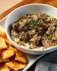 Bowl of traditional Baba Ghanoush served with fresh vegetables and pita bread