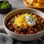 Delicious bowl of beef chili garnished with fresh herbs