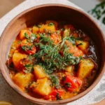 A bowl of hearty vegetable stew filled with colorful veggies and herbs.