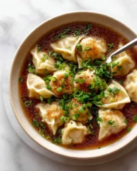 Bowl of easy wonton soup with fresh ingredients and garnished greens