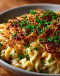 French Onion Chicken Orzo Casserole topped with melted cheese and herbs.
