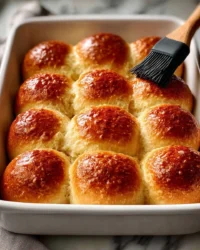 Freshly baked homemade dinner rolls on a wooden table
