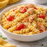 Delicious Garlic Baked Feta Salmon Pasta served in a bowl with herbs.