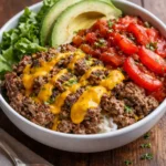 High-protein cheeseburger bowls with fresh ingredients and toppings.