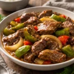 Delicious slow cooker pepper steak served with rice and vegetables.