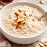 Bowl of tasty coconut cream oats topped with fruits and nuts.
