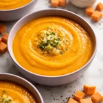 Bowl of tasty roasted sweet potato and leek soup garnished with herbs