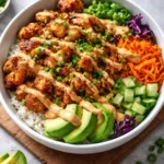 Delicious Bang Bang Chicken Bowl garnished with fresh vegetables and sauce