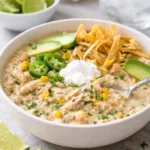 Creamy crockpot white chicken chili in a bowl topped with cilantro