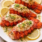 Delicious garlic butter lobster tails garnished with fresh herbs.