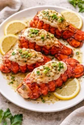 Delicious garlic butter lobster tails garnished with fresh herbs.