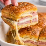 Tasty ham and cheese sliders served on a platter with garnishes