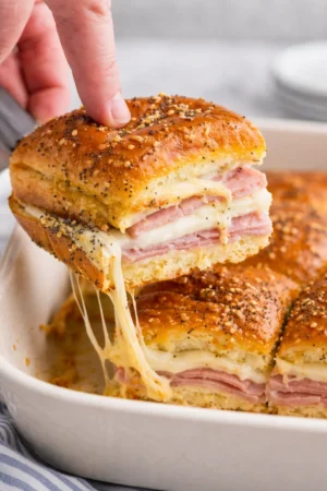 Tasty ham and cheese sliders served on a platter with garnishes