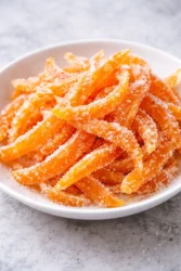 Bowl of homemade candied orange peels garnished with mint