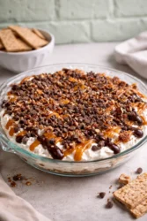 Delicious Turtle Cheesecake Dip topped with chocolate and nuts in a bowl
