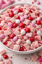 Valentine's Day themed Muddy Buddies snack mix in a heart-shaped bowl.