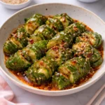Asian Spicy Cucumber Salad garnished with herbs and chilies