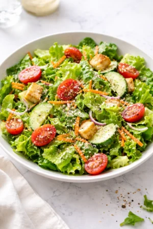 Classic house salad with mixed greens, tomatoes, cucumbers, and dressing.