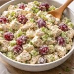 Bowl of creamy chicken salad with fresh vegetables and herbs