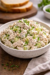Bowl of simple chicken salad with fresh vegetables and dressing