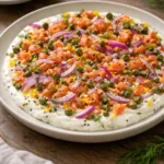 Creamy smoked salmon dip served on a bagel slice with fresh herbs