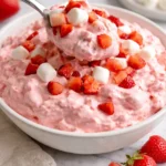 Bowl of Strawberry Fluff Jello Salad with strawberries and whipped cream