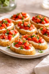 Whipped feta tomato crostini garnished with fresh herbs