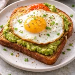 Delicious avocado-egg toast topped with fresh herbs and spices