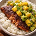 BBQ salmon bowls topped with mango avocado salsa on a rustic wooden table