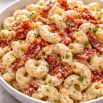 Creamy Bacon Cheddar Ranch Pasta Salad served in a bowl with bacon and cheese