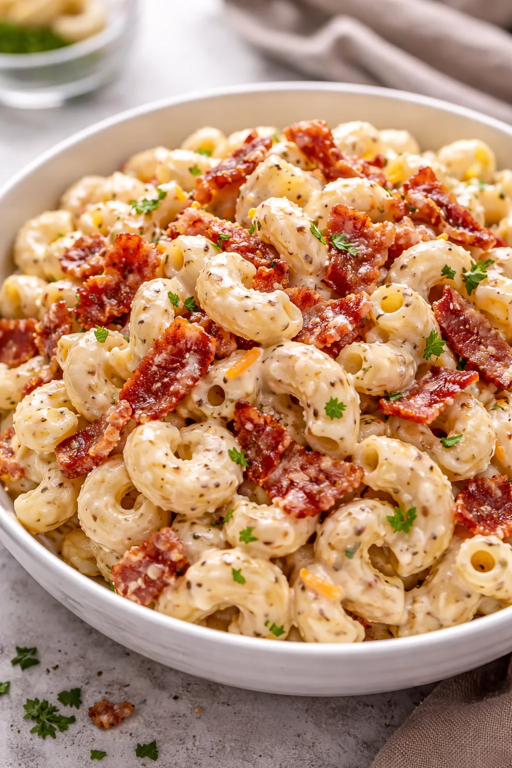 Creamy Bacon Cheddar Ranch Pasta Salad served in a bowl with bacon and cheese