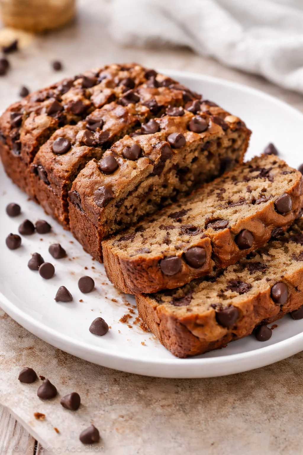 Slice of healthier chocolate chip banana bread on a wooden cutting board