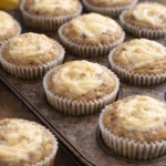 Freshly baked moist banana cream cheese muffins on a cooling rack