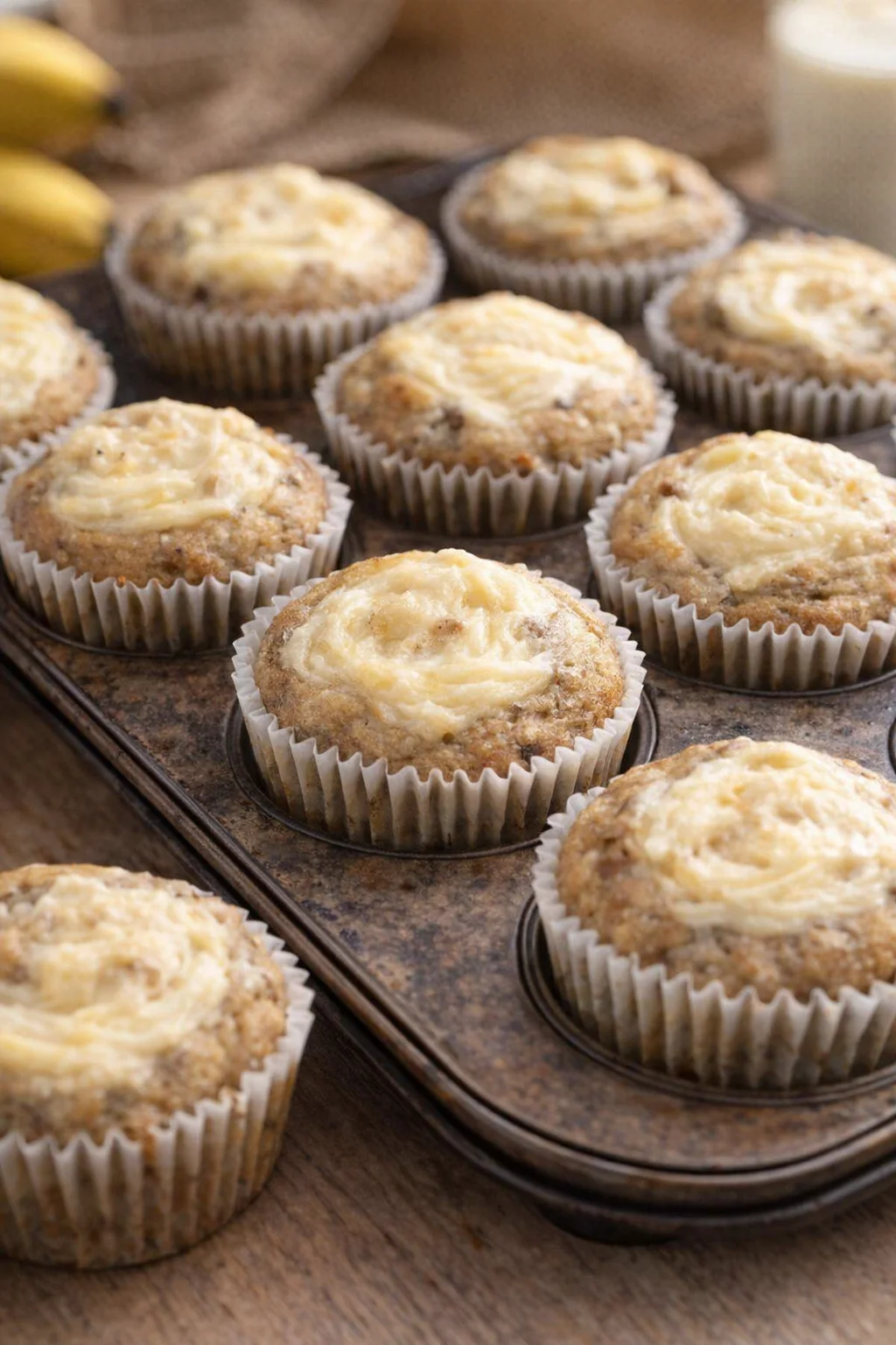 Freshly baked moist banana cream cheese muffins on a cooling rack