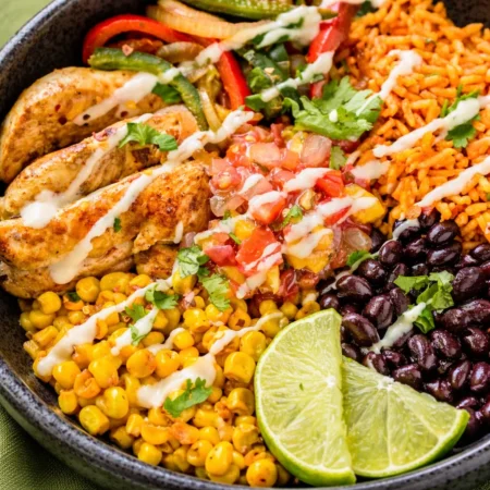 Healthy chicken and rice bowl with colorful veggies and flavorful seasonings.