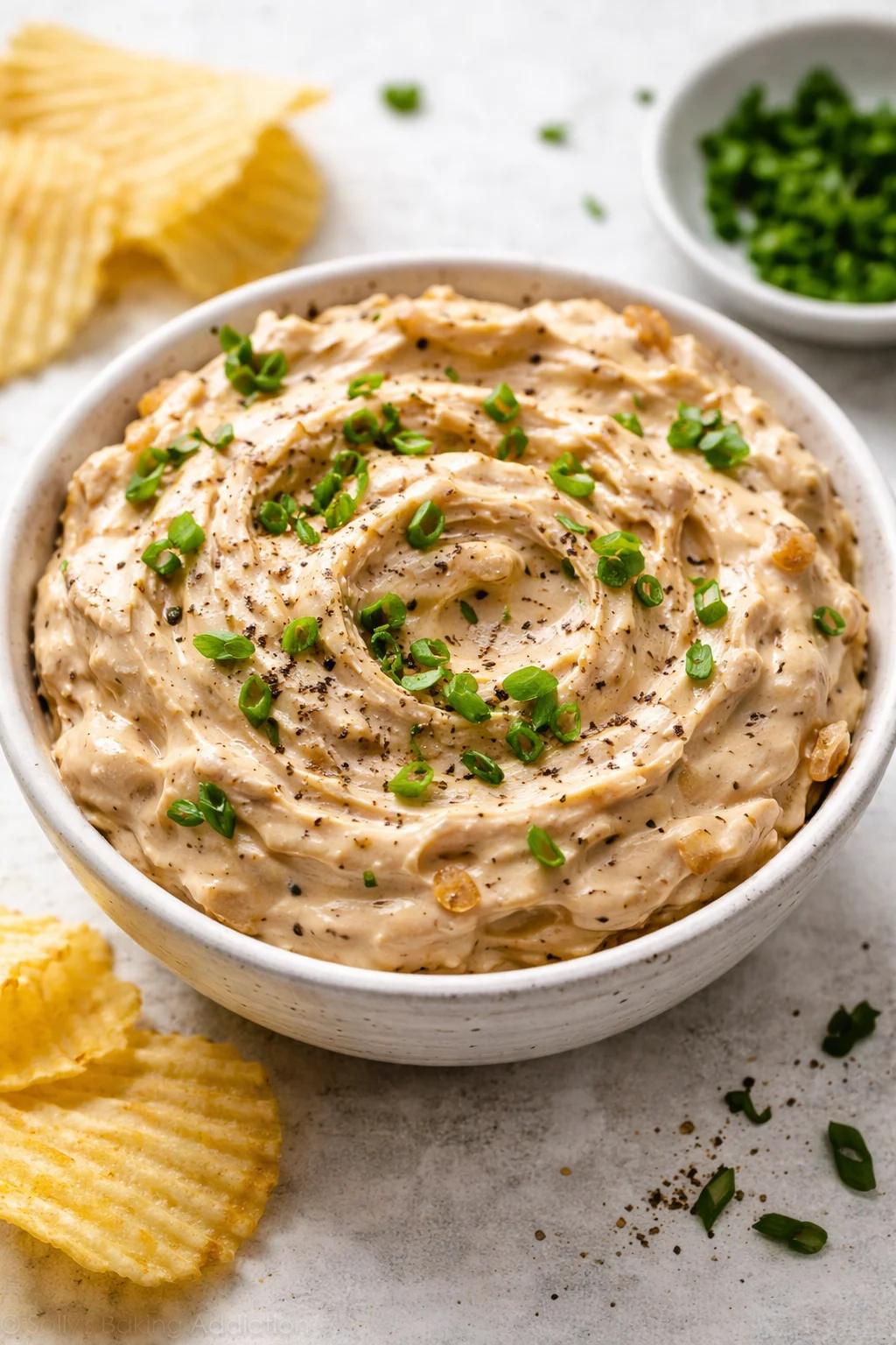 Delicious brandied caramelized onion dip served in a bowl with crispy chips